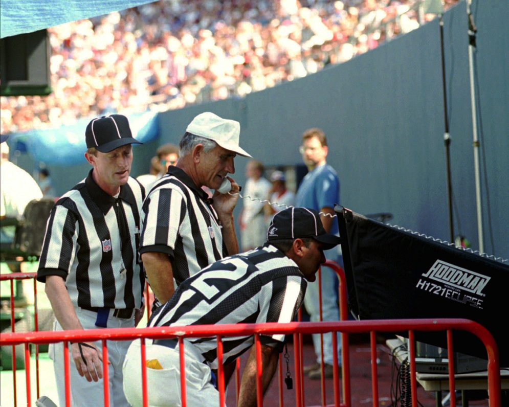 Referee Bob McElwee&#xA0;reviews a play with an on-field monitor during the 1996 preseason testing of the new system. (AP Photo/Bill Kostroun)