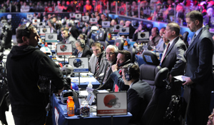 NFL Draft representatives sit at team tables during the NFL Draft.