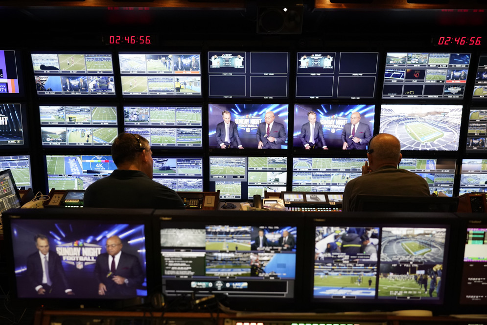 Producer Robert Hyland and director Drew Esocoff work inside the NBC Sports trailer in preparation for the network&#x27;s &quot;Sunday Night Football&quot; broadcast in 2022. Every Sunday night during the season, his crew produces what fans see from multiple cameras deployed throughout the stadium. (AP/Jae C. Hong)