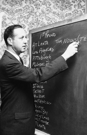 Former Commissioner Pete Rozelle records the picks on a chalkboard during the first combined NFL and AFL draft in 1967.