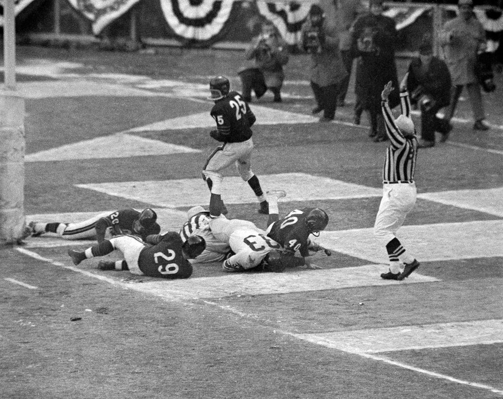 El segundo &#225;rbitro Sam Wilson hace las se&#241;ales de una anotaci&#243;n en el partido por el campeonato de la NFL de 1956 entre los Chicago Bears y los New York Giants. (Fotograf&#237;a AP/Harry Harris)