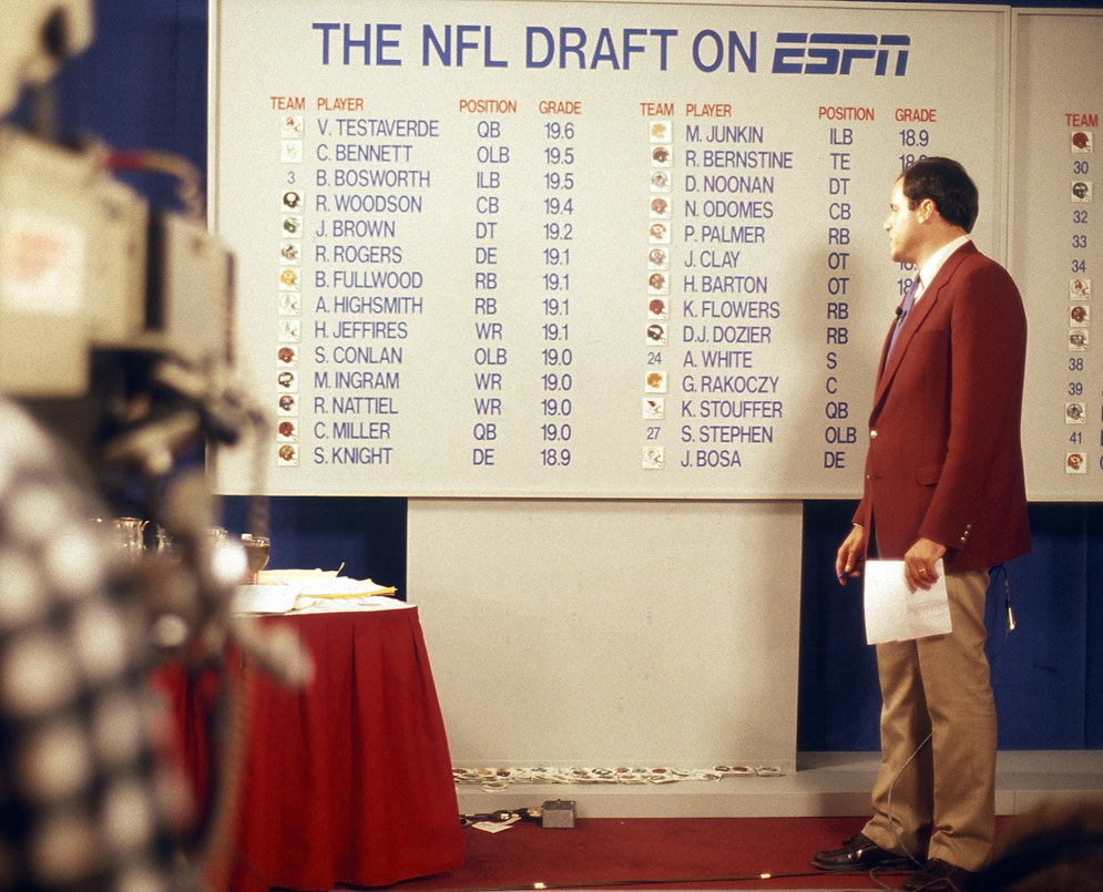 ESPN&#x27;s Chris Berman looks at the draft board from the 1987 NFL Draft. ESPN helped make the NFL Draft a television event when it started broadcasting it in 1980. (AP Photo/Paul Spinelli)