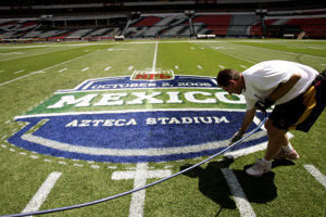 A man draws the logo on the NFL Fútbol Americano game at Estadio Azteca in Mexico City.