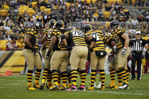 Pittsburgh Steelers players huddle before the snap.