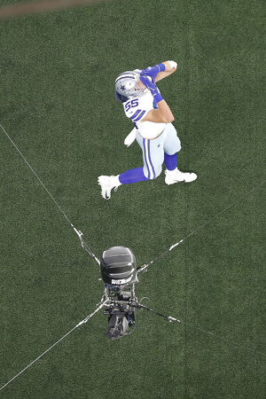 A camera hanging above the field records a Dallas Cowboys player.