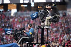 A Fox Sports camera man operates a TV camera during an NFL game.